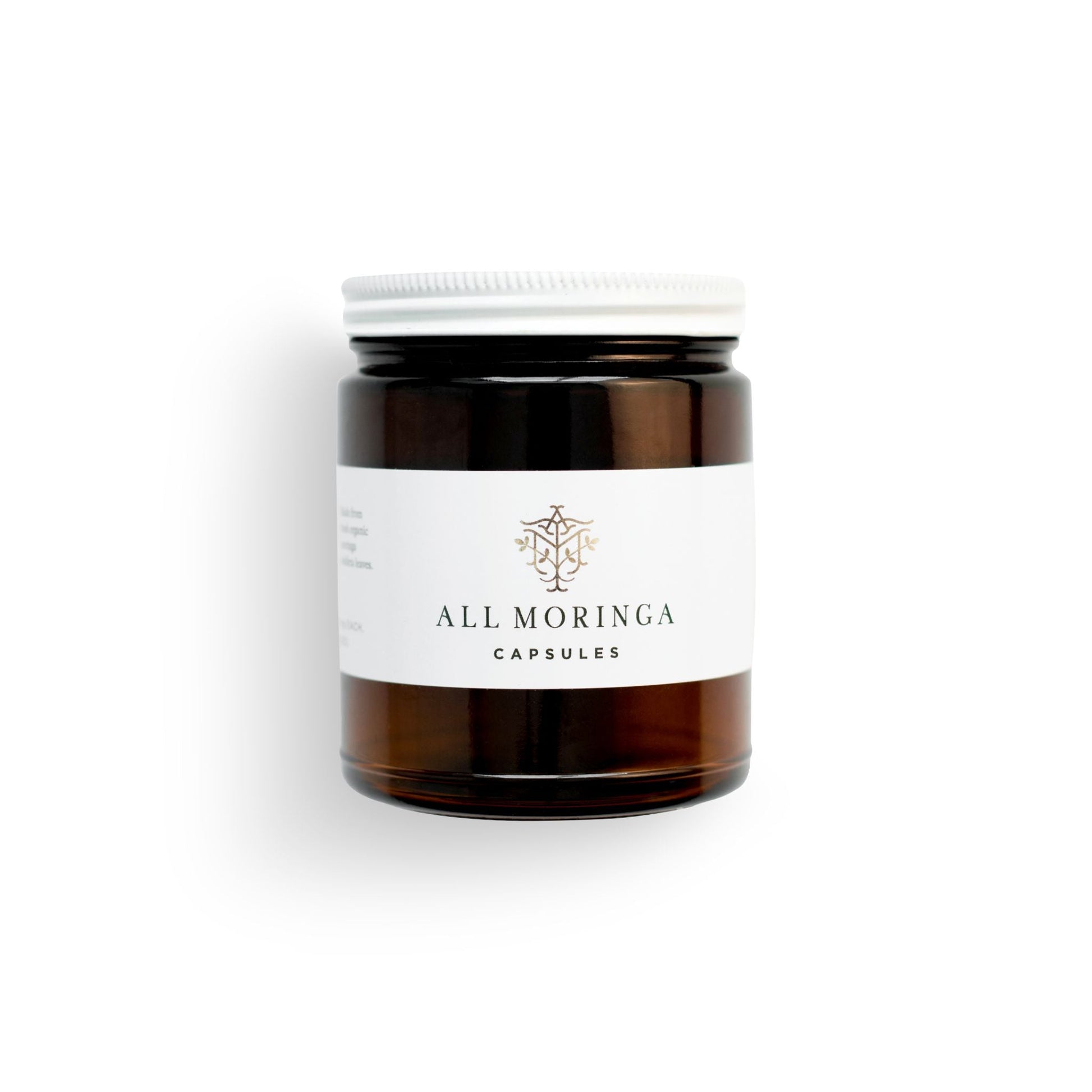 Superfood organic moringa leaves capsules in a glass jar and a metal cup